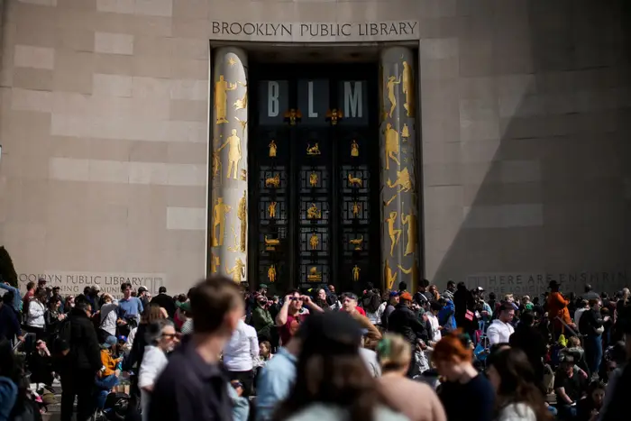 People gather to watch the solar eclipse outside the Brooklyn Public Library main branch on April 8, 2024.